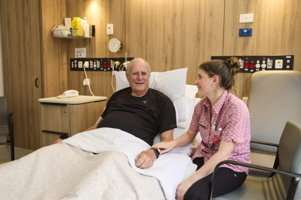 Cabrini nurse sitting beside the patients bed