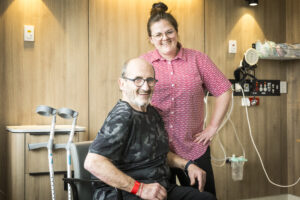 Nurse with patient in chair with crutches - Orthopaedic